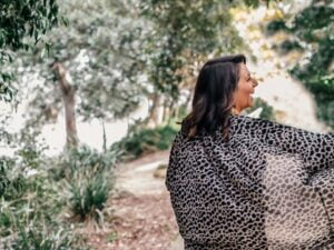 woman with her back to the camera and her arm out smiling and laughing outside