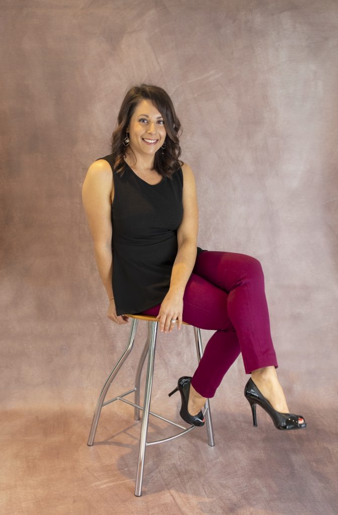 woman sitting on a stool looking at the camera