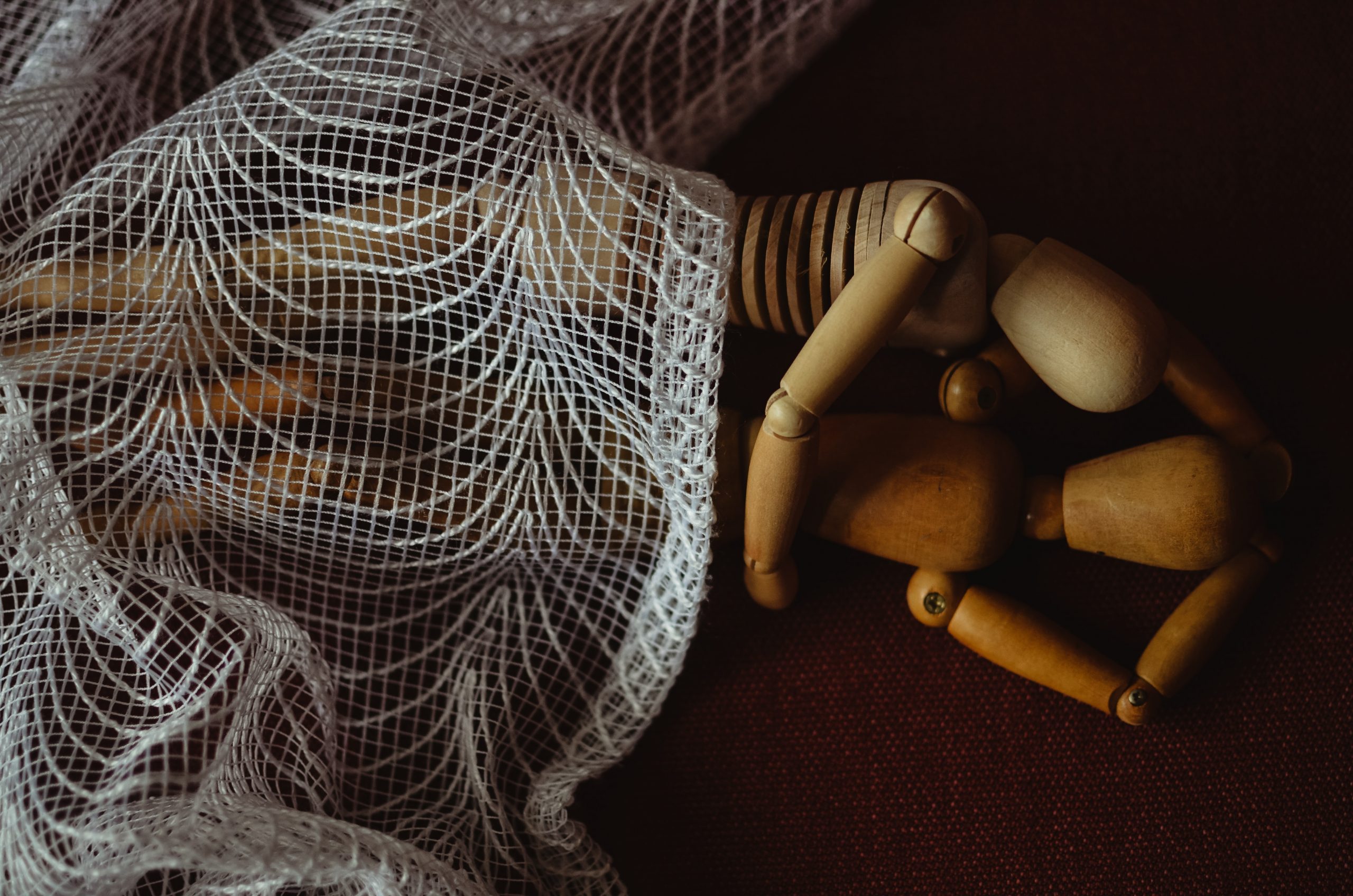 figurines lying down hugging each other under net blanket demonstrating a position after sex after birth
