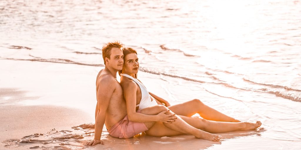couple lying on beach looking at sunset to increase low sexual desire