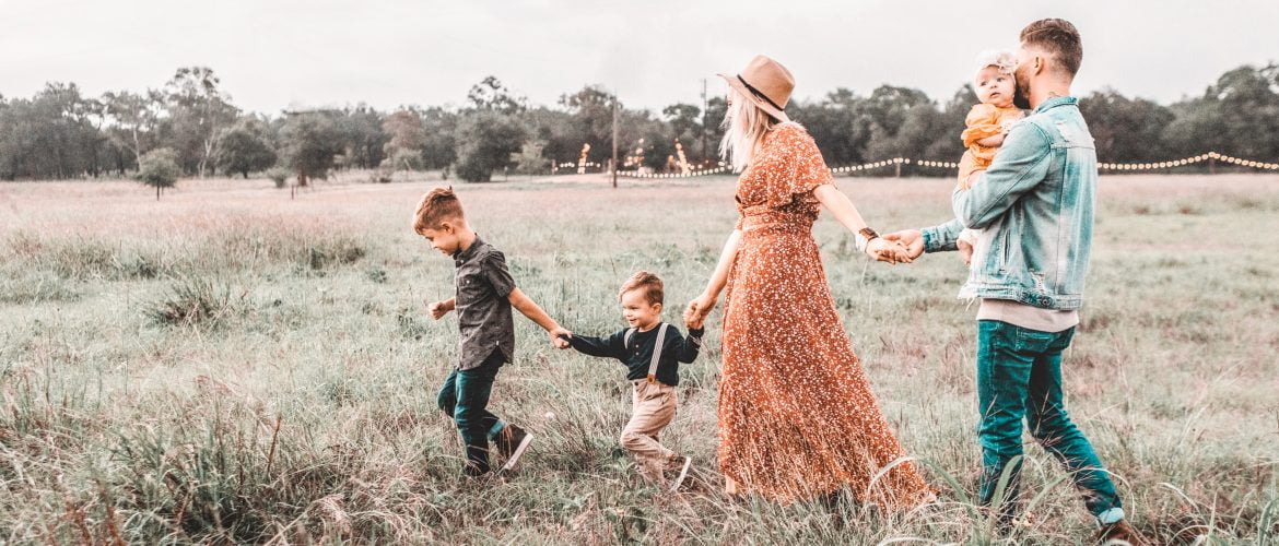 parents holding hands in line with kids. Parents maintaining intimacy whilst with kids thinking about sex after birth and how to revive their sexual desire