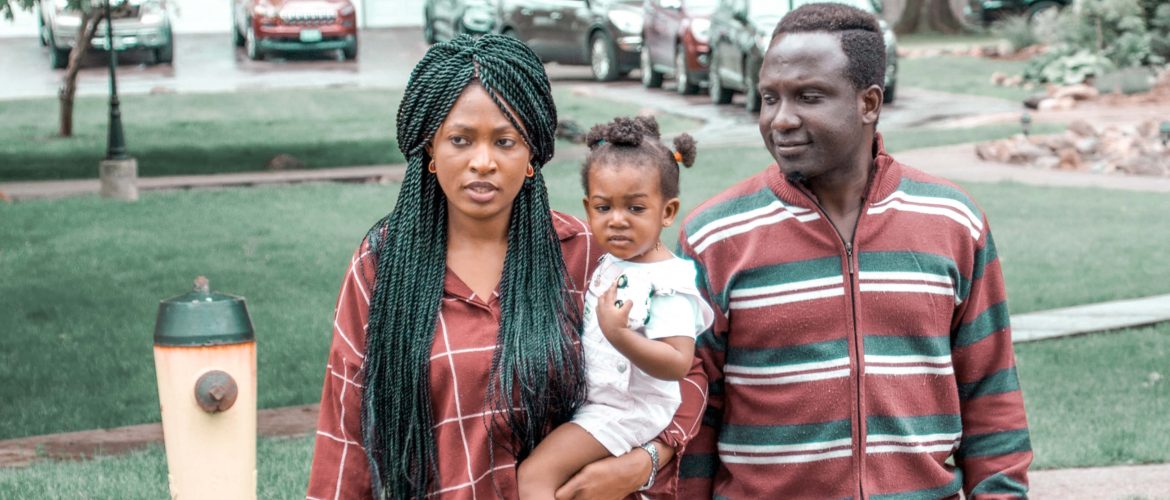 mum carrying child with husband. Mum looks sad because of low self-identity and child looks sad. Dad looking at mum