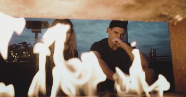 couple looking at fire, couple contemplating relationship problems, woman sitting next to man, couple