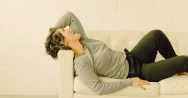 woman lying on the couch smiling and laughing