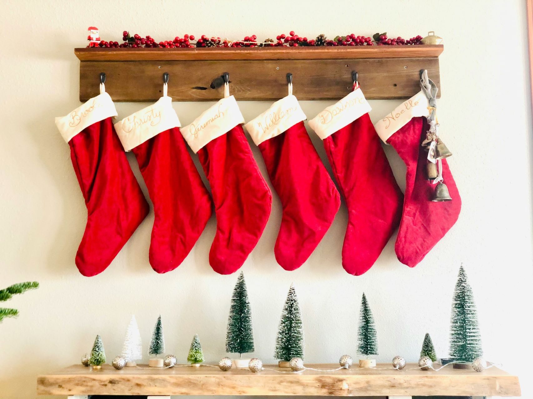 christmas stockings hanging on a wooden board.