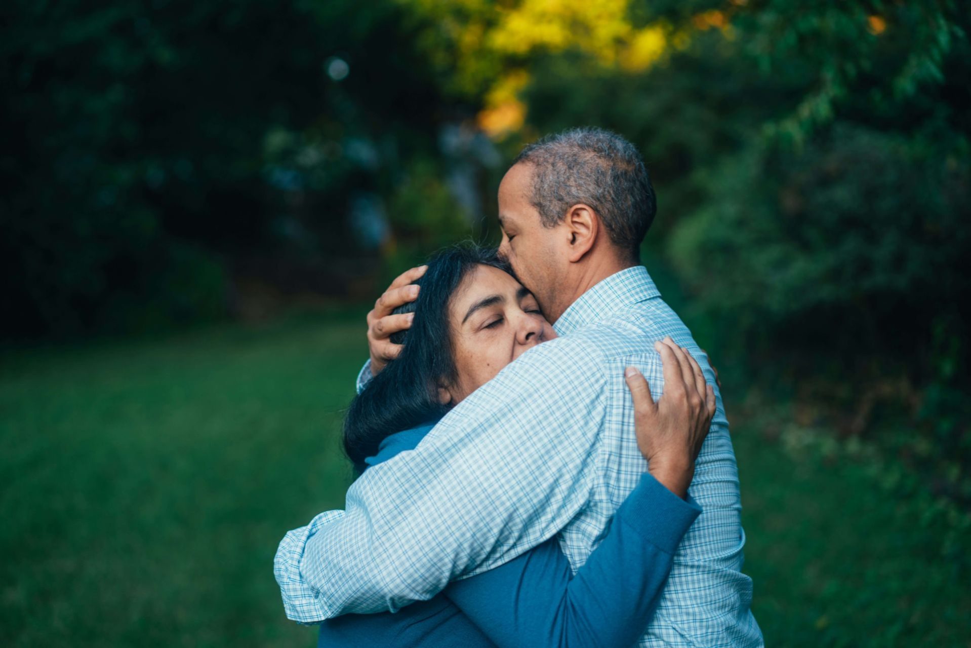 man and woman over 40 hugging in a garden