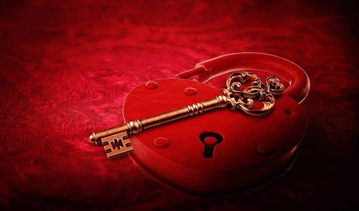gold key sitting on a red lock to open an intimate sensual door